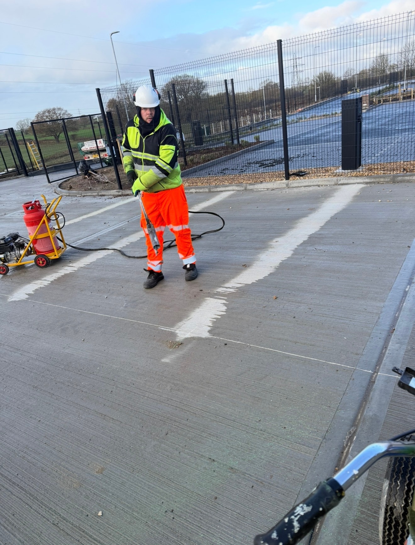 Markex operative applying thermoplastic bay markings on a new concrete car park surface — Colchester