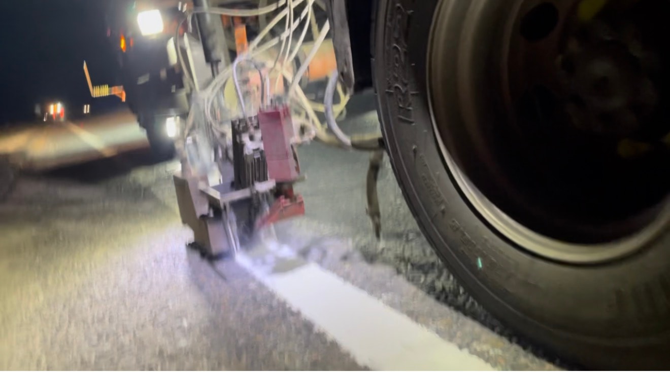 Road line marking in progress — King's Lynn. Thermoplastic white line being applied by machine during a night-time road marking operation.